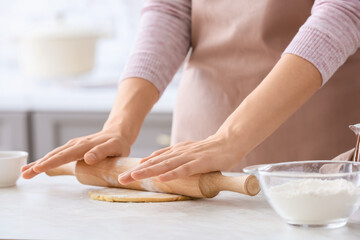 Obraz na płótnie Canvas Woman making dough on table in kitchen