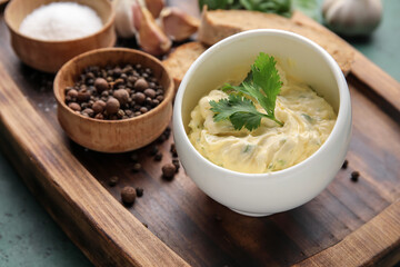 Bowl with garlic butter and spices on table, closeup