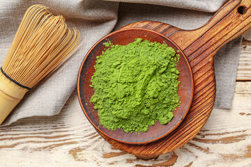 Composition with powdered matcha tea on light wooden background