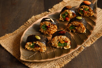 fried rice sushi served in a brown plate on the table