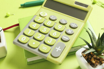 Modern calculator and stationery on color background