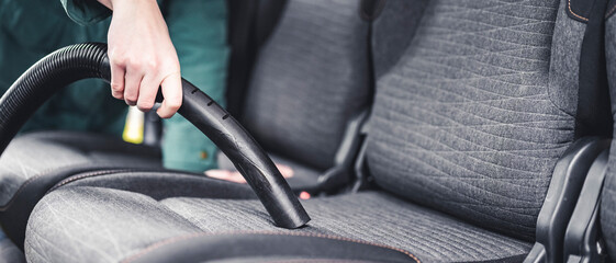 Woman hoovering a car cabin. Vacuum cleaning car seats interior..