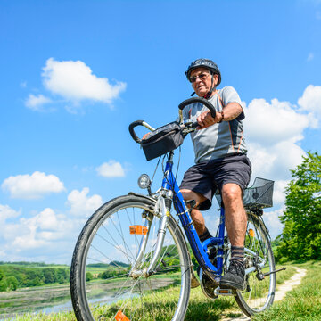 Älterer Mann genießt die herrliche Natur bei einer Radtour im Sommer
