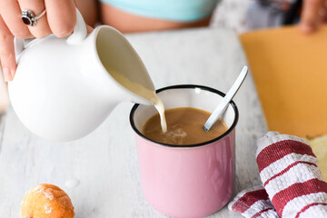 Coffee and milk on the table. Pouring milk into coffee/latte/ Breakfast table-starting a day