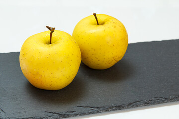 Apple fruits on the black stone board.