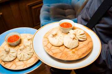 Juicy khinkali on a plate with sauce.