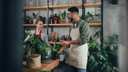 Shop assistants working in indoor potted plant store, small business concept.