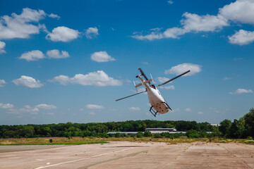 A white helicopter takes off from the runway