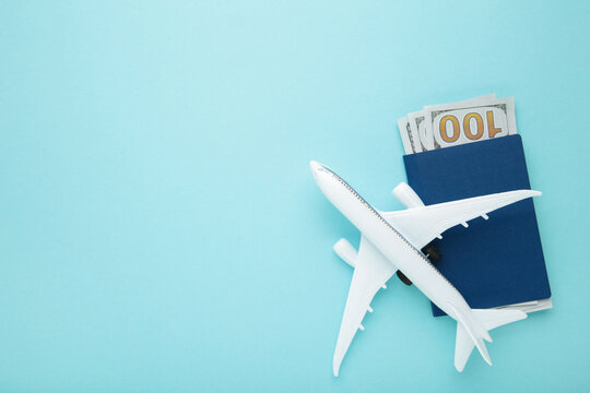 Preparation for Traveling concept, airplane, money, passport on blue background with copy space.