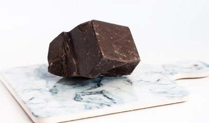 a piece of dark chocolate on a light marble board