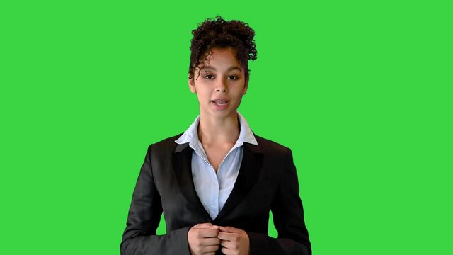 African American woamn in a black jacket talking on camera on a Green Screen, Chroma Key.