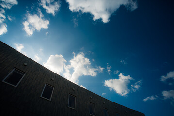 建物から覗く太陽の光と美しい青空