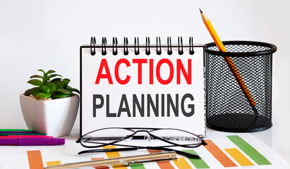Notebook with Tools and Notes with text ACTION PLANNING , business concept