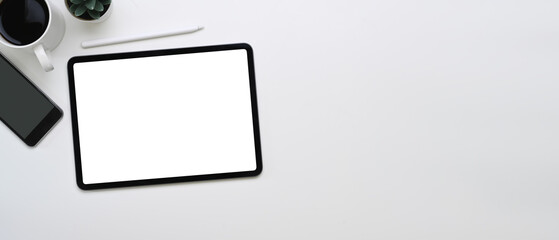 Horizontal photo of mock up digital tablet, smartphone, coffee cup and copy space on white background.