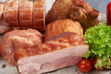 Many different large pieces of smoked pork on parchment. Still life with semi-finished meat products. Close-up