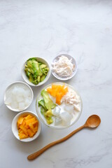 a glass of es teler or various fruits with coconut milk soup and ice cubes
