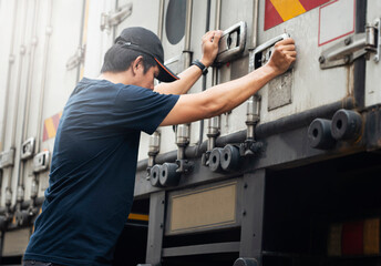 Truck driver closing steel door of cargo container. Industry freight truck transportation.