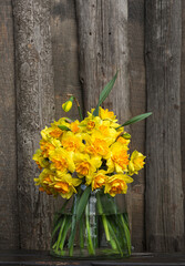 Fototapeta na wymiar Bouquet of yellow daffodils in a glass vase
