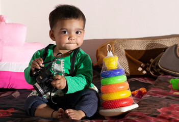 Asian Indian baby girl portrait closeup playing with toys. A cute baby girl .