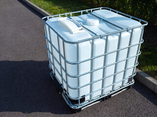 White square water tank. Water tank with metal grate. White huge container for liquid. Large water...