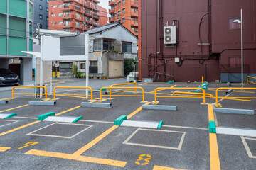 Parking in Tokyo. Japanese cities infrastructure. Street parking in Tokyo. Parking lot with yellow markings. Car-park makes it impossible for car to leave without payment. Japanese technology. - obrazy, fototapety, plakaty
