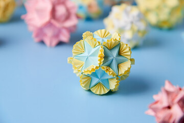 Set of multicolor handmade modular origami balls or Kusudama Isolated on blue background. Visual...
