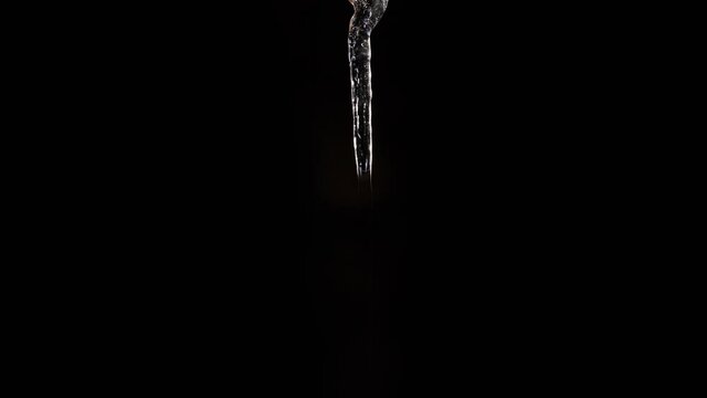 Time lapse sequence of a growing icicle in front of a black background