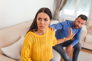 Young man begging his girlfriend to forgive him. Husband asking his pretty wife for forgiveness...
