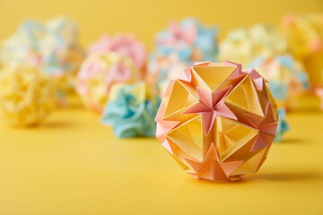 Set of multicolor handmade modular origami balls or Kusudama Isolated on yellow background. Visual...