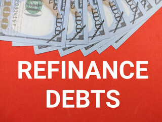 Selective focus.Word REFINANCE DEBTS with dollar banknote on red background.Business concept.