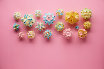 Set of multicolor handmade modular origami balls or Kusudama Isolated on pink background. Visual...