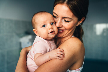 Happy mother and baby hugging and playing together.