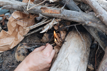 lighting a fire in the forest with matches
