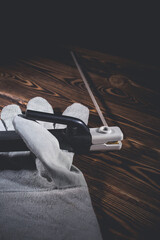 The holder of the welding electrode with an electrode, lie in a welding glove on a wooden background. Studio photo in hard light.