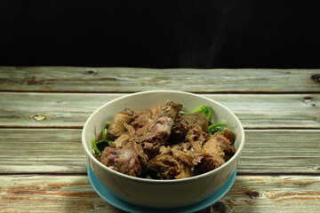 Traditional soup of steamed duck and chicken meat serving with fresh vegetable in the bowl. Famous hot bowl menu in Chinese restaurant. 