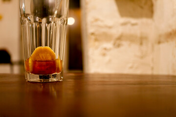 Brown refreshing cocktail with lemon on table