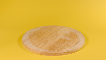 Dirty wooden round board on yellow background