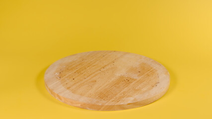 Dirty wooden round board on yellow background