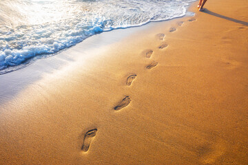footprints on  tropical beach and beautiful  wave