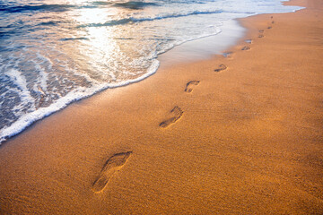 footprints on  tropical beach and beautiful  wave