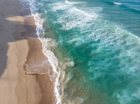 Aerial view of person walking along clear ocean beach Indian Ocean in Ponta do Ouro, Mozambique