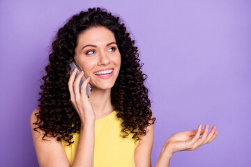 Photo of charming young girl speak phone arm palm explaining beaming smile isolated on violet color background