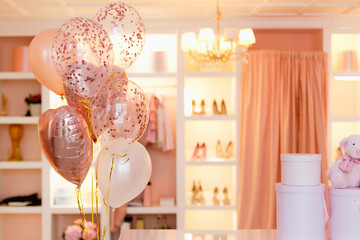 Dressing room, changing room, clothes rack in pink and peach colors with balloons.