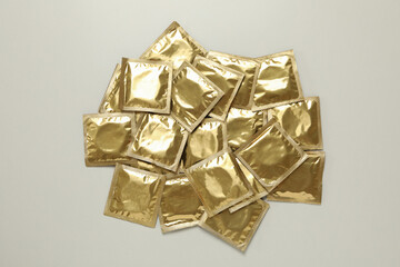 Heap of blank condoms on light gray background