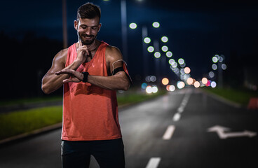 Man resting after night workout in the city, he is checking pulse.