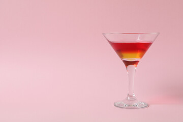 Cocktail glass with strawberry and orange jelly on pink background