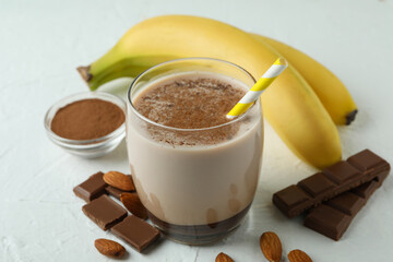 Concept of delicious food with chocolate milkshake and banana on white textured table