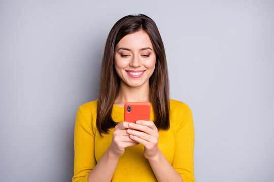 Photo Of Optimistic Brunette Nice Lady Look Telephone Wear Yellow Sweater Isolated On Grey Color Background