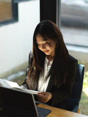 Fototapeta premium Businesswoman working with document file and digital tablet on coffee table