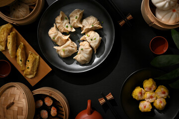 Dinning table in Chinese restaurant with plate and bamboo steamer with dumplings and pork buns